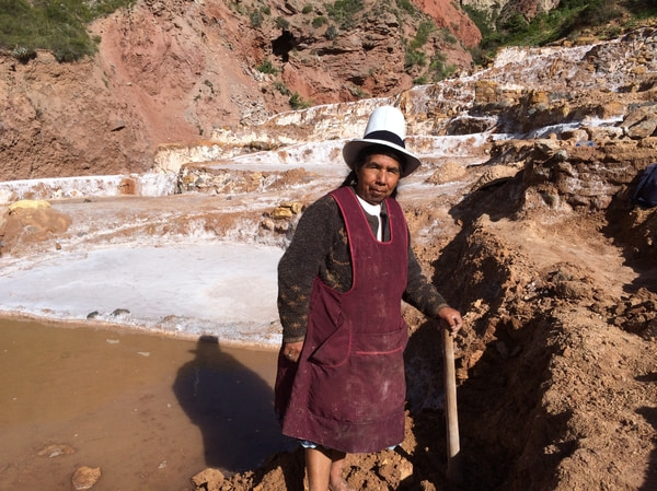 A local Quechua woman harvesting salt from her ponds at Salineras de Maras