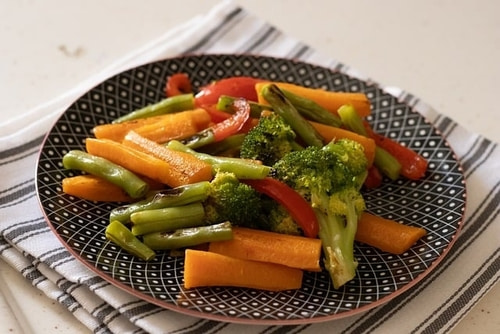 A plate of vegetables that will improve your health if you eat them. Salt will enhance their flavor.