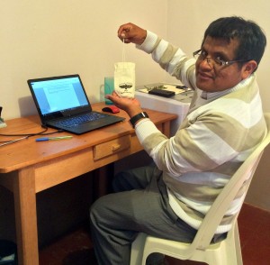 Juan Cesar, a local export partner, seated at a desk, proudly displaying a pouch of Sacred Valley Salt