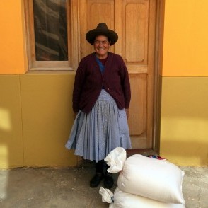 Señora Vilma, standing next to large sacks of salt from her family's ponds at Salineras de Maras