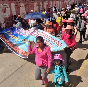 Men women and children carrying large banners marching through the streets